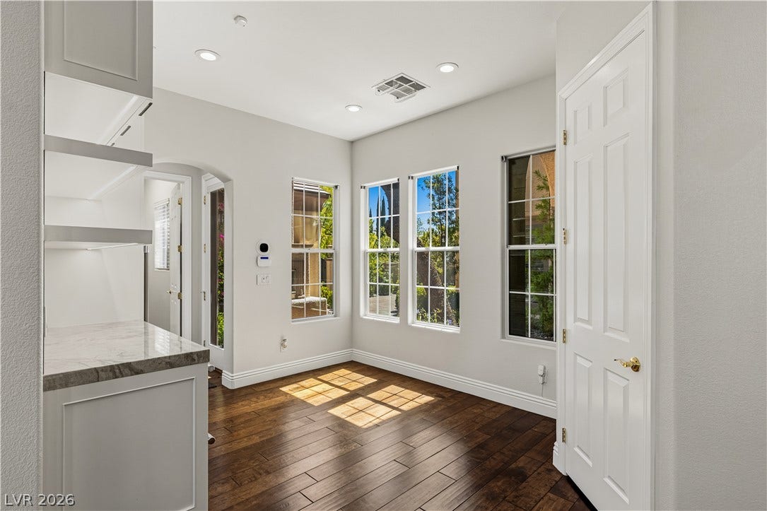 1201 Mersault Court, Las Vegas, NV 89144 Rich hardwood floors and classic tall windows frame this versatile interior space.