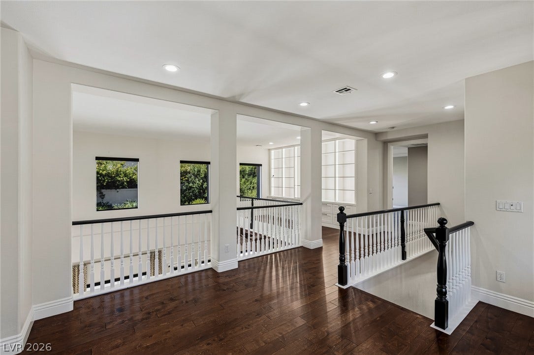 1201 Mersault Court, Las Vegas, NV 89144 Rich hardwood floors and elegant balustrades frame this bright upper-level landing.