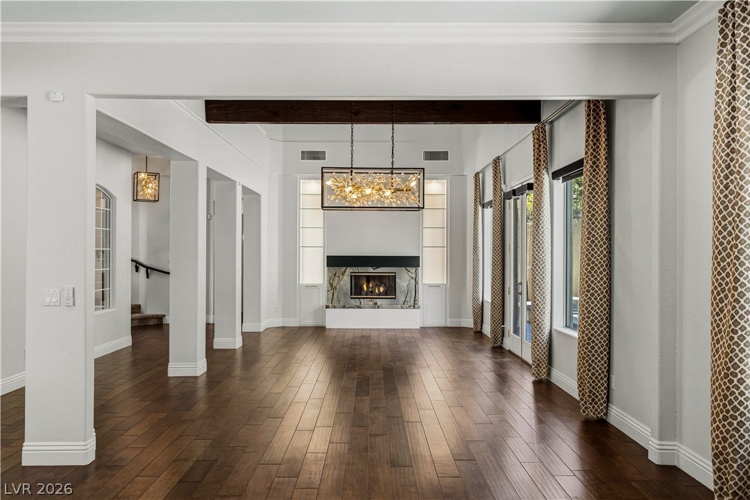 1201 Mersault Court, Las Vegas, NV 89144 Gleaming hardwood floors and a modern fireplace elevate this light-filled open living space.