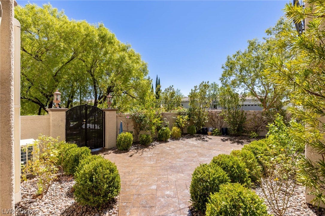 1201 Mersault Court, Las Vegas, NV 89144 A private stone courtyard is enclosed by walls and gated entry among mature trees.