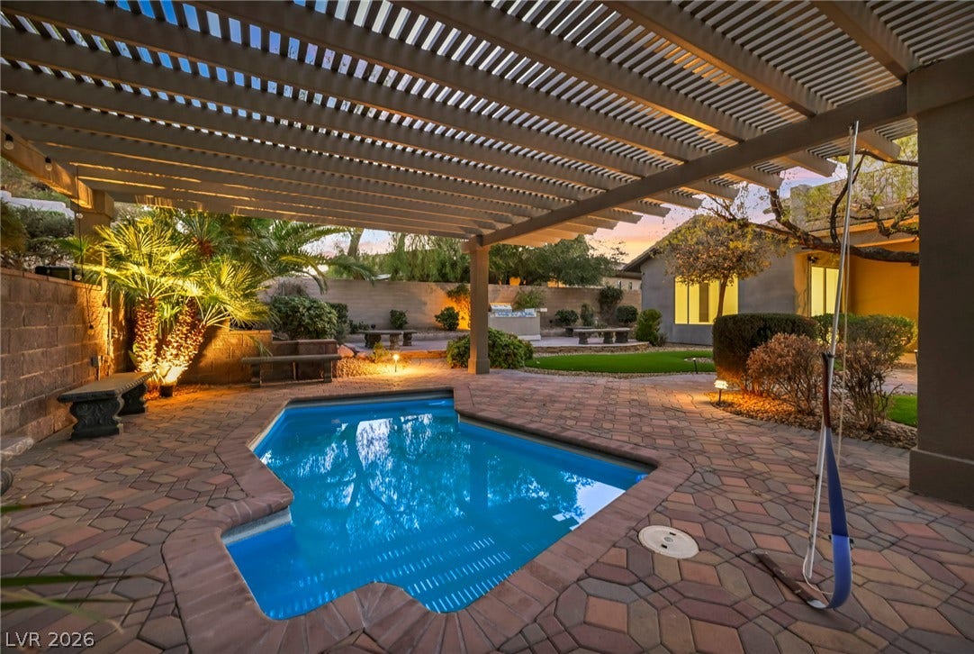 17 Winding Road, Henderson, NV 89052 A shaded patio structure overlooks a sparkling in-ground pool surrounded by paver stone decking.