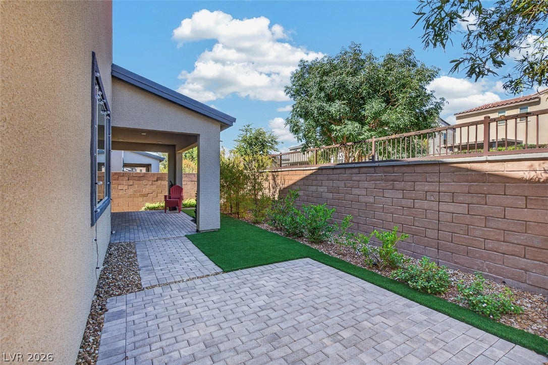 6849 Desert Finch Street, North Las Vegas, NV 89084 An inviting paved patio area extends alongside the home, bordered by a solid block wall.