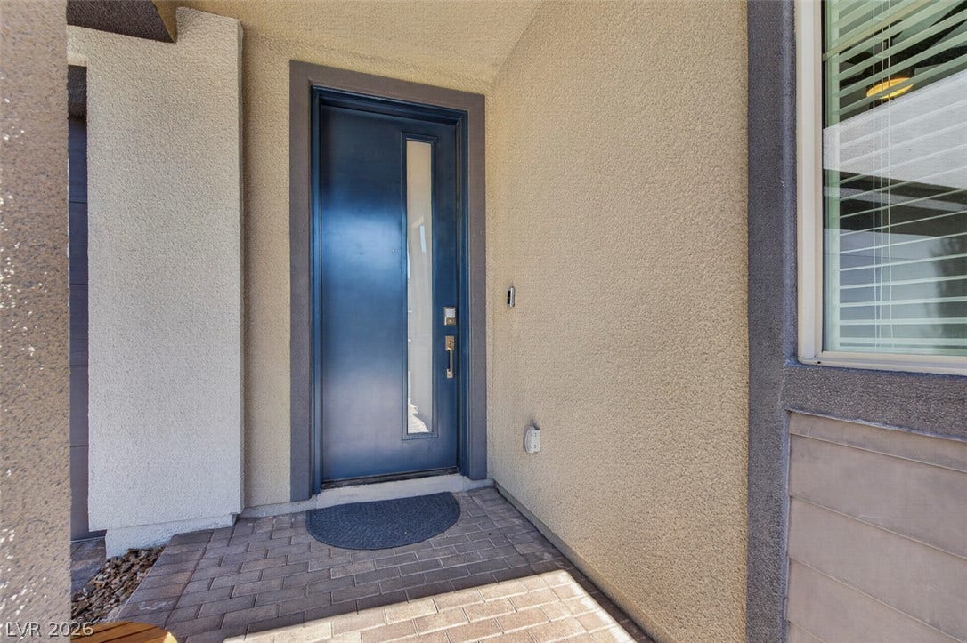 6849 Desert Finch Street, North Las Vegas, NV 89084 An inviting recessed entry features a modern glass-paneled door and a paved walkway.