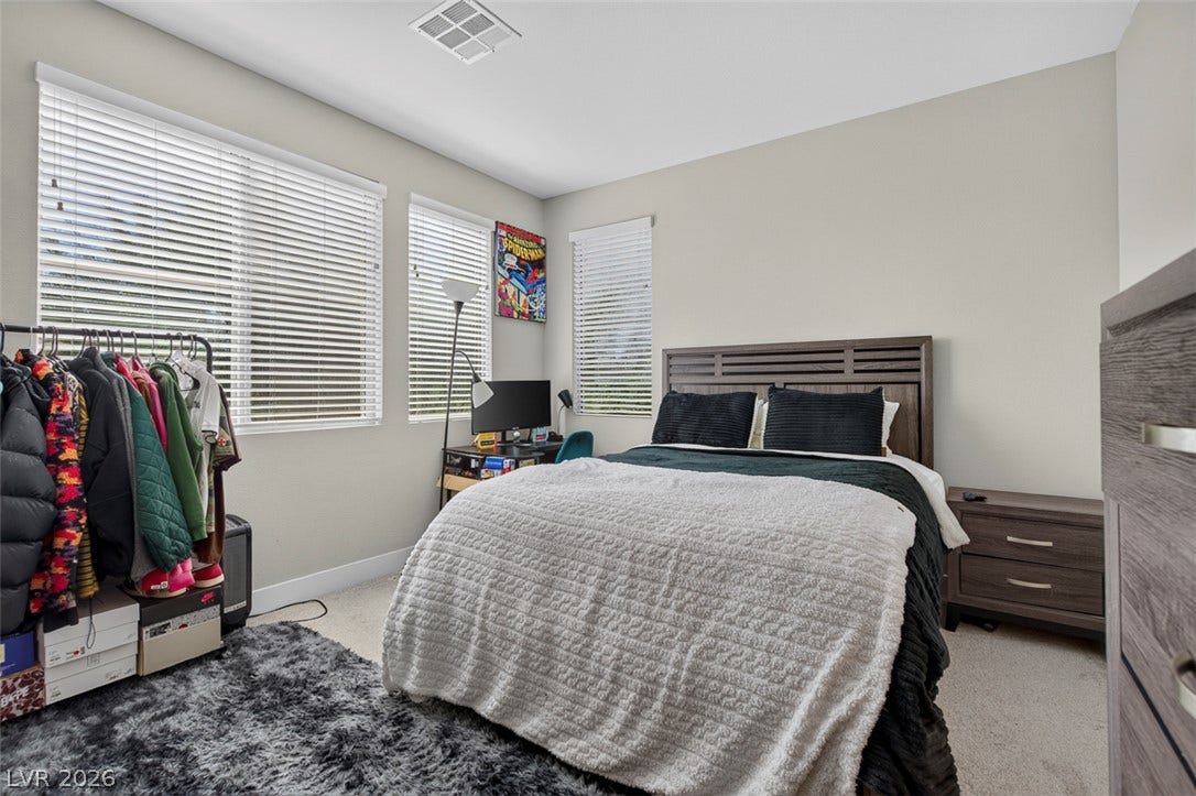 6849 Desert Finch Street, North Las Vegas, NV 89084 Natural light pours through several windows, highlighting the clean lines of this modern bedroom.