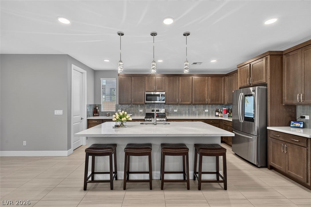 6849 Desert Finch Street, North Las Vegas, NV 89084 Rich wood cabinetry contrasts beautifully with sleek stone countertops in this modern culinary space.