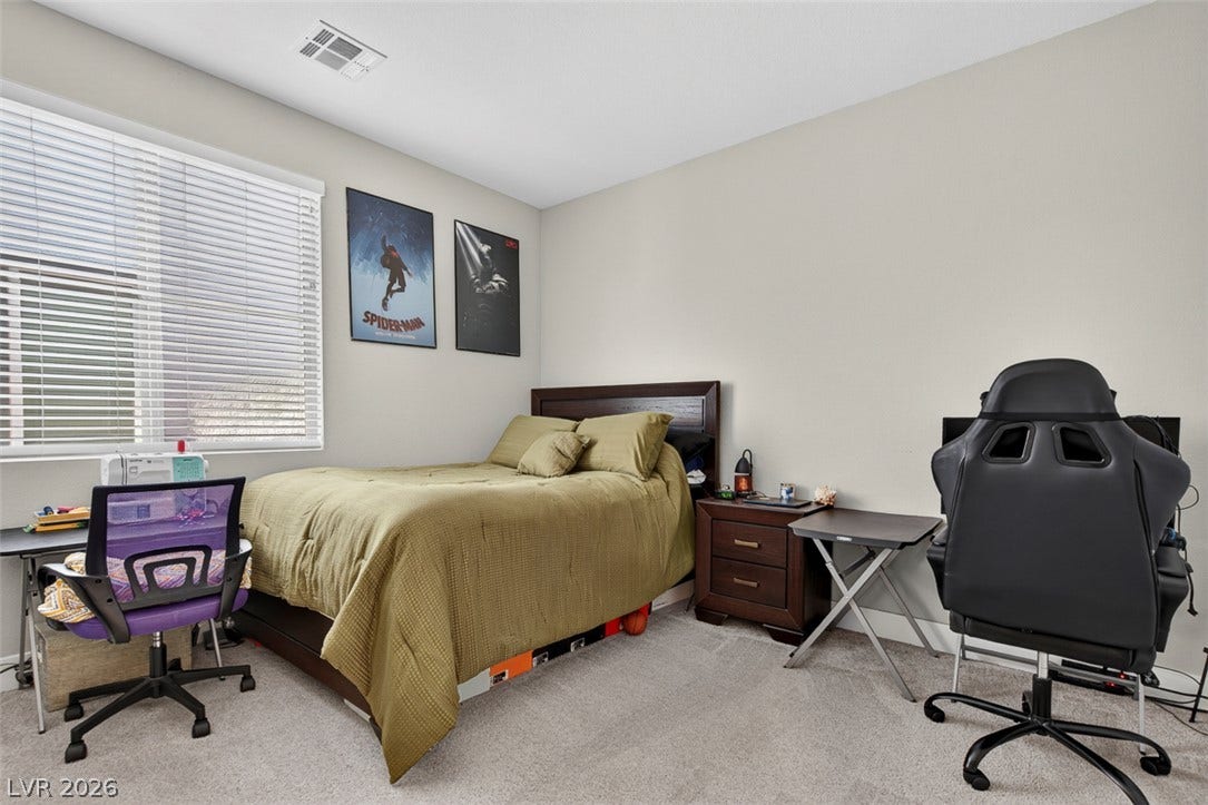 6849 Desert Finch Street, North Las Vegas, NV 89084 A spacious secondary bedroom features neutral wall tones and soft carpeting underfoot.