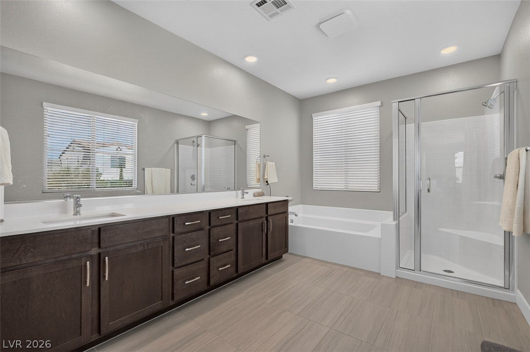 6849 Desert Finch Street, North Las Vegas, NV 89084 Clean lines and a spacious dual vanity define this modern primary bathroom suite.
