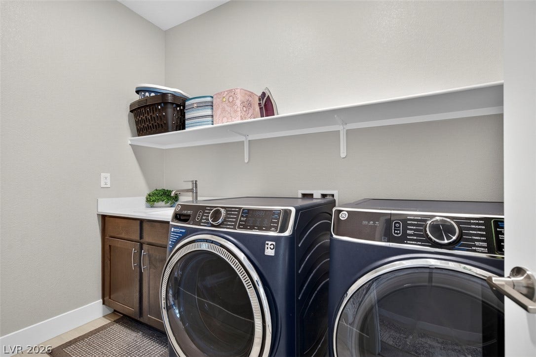 6849 Desert Finch Street, North Las Vegas, NV 89084 An organized laundry space features built-in cabinets and overhead shelving for storage.