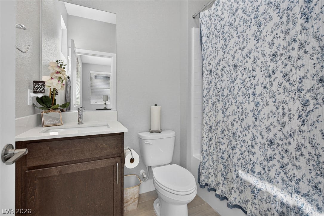 6849 Desert Finch Street, North Las Vegas, NV 89084 Ensuite bathroom. A classic vanity with stone counters complements the sleek tile flooring in this bathroom.