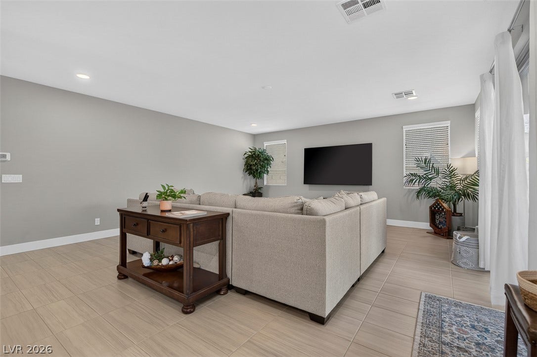 6849 Desert Finch Street, North Las Vegas, NV 89084 An open living space features durable tile flooring, recessed lighting, and sliding glass doors.