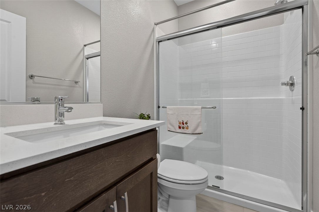 6849 Desert Finch Street, North Las Vegas, NV 89084 Downstairs Full Bathroom. A contemporary vanity with stone counters complements the sleek tiled walk-in shower.