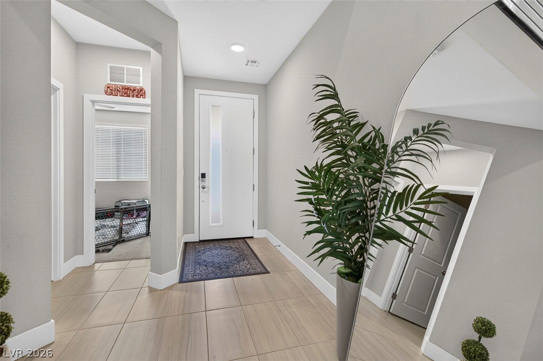 6849 Desert Finch Street, North Las Vegas, NV 89084 Smooth tile flooring and clean lines define this modern entry hall with high ceilings.