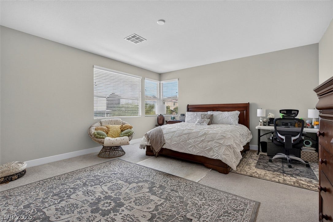 6849 Desert Finch Street, North Las Vegas, NV 89084 Generous window placements invite natural light across the comfortable carpeted bedroom.