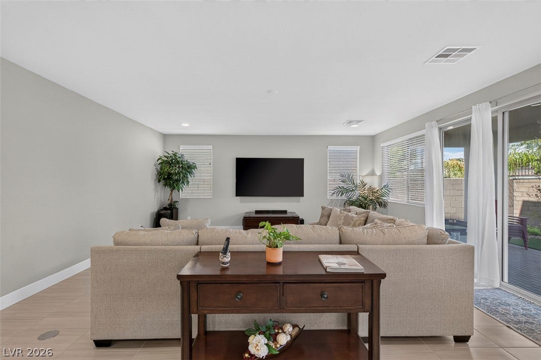 6849 Desert Finch Street, North Las Vegas, NV 89084 Gleaming tile floors and sliding glass doors define this airy open-concept living space.