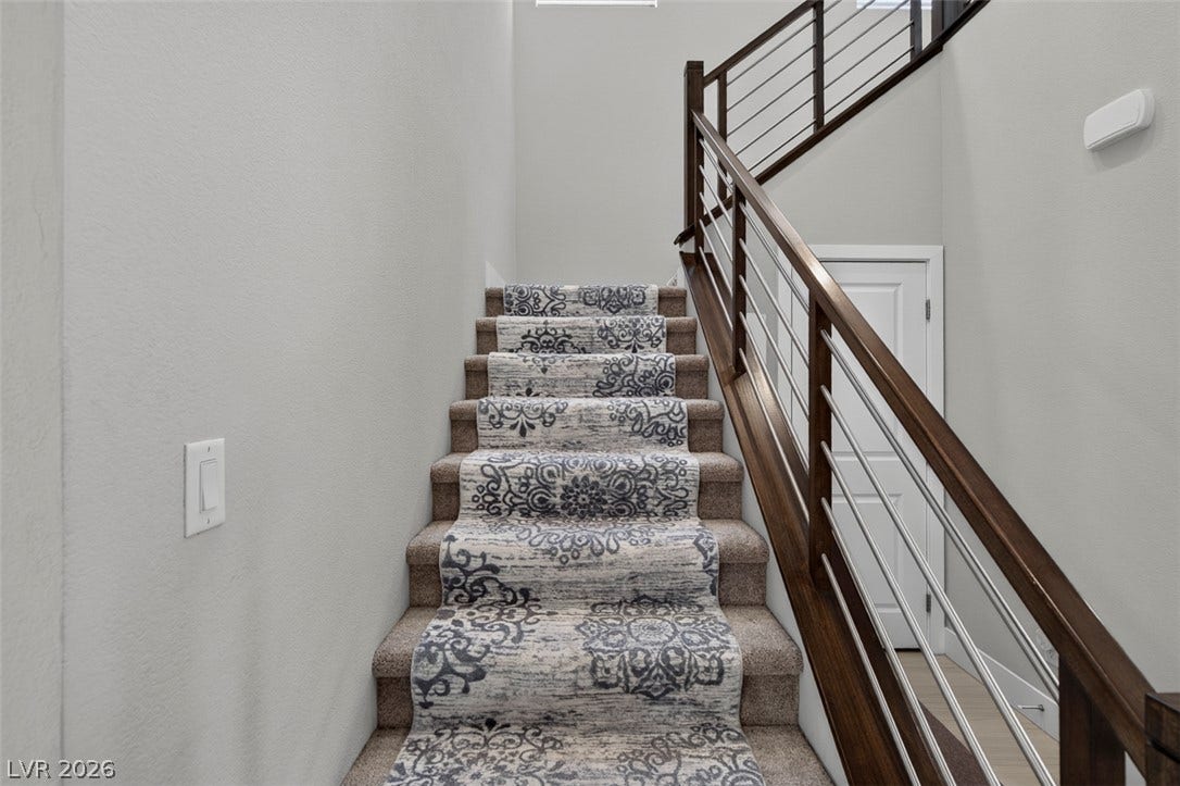 6849 Desert Finch Street, North Las Vegas, NV 89084 Modern metal and wood railings accent a staircase featuring a patterned runner.