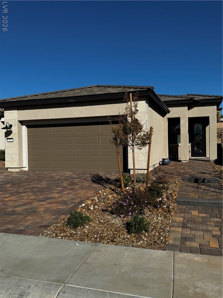 162 Palm Fox Court, Henderson, NV 89011 An inviting stone-paved driveway leads to a modern exterior with a stucco finish.