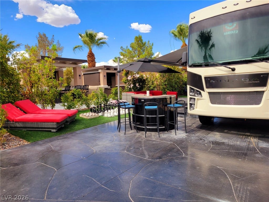 8175 Arville Street, #293, Las Vegas, NV 89139 A spacious outdoor living setup features custom patterned paving alongside a landscaped lawn.
