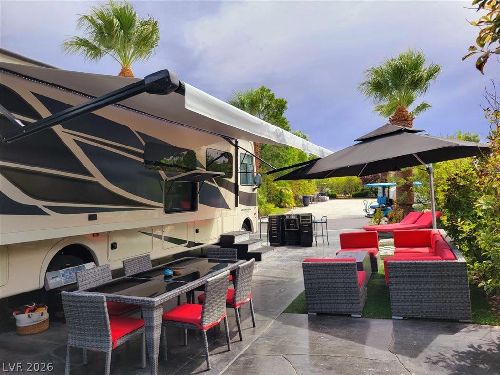 8175 Arville Street, #293, Las Vegas, NV 89139 Lush palm trees frame a concrete patio designed for relaxed outdoor living.