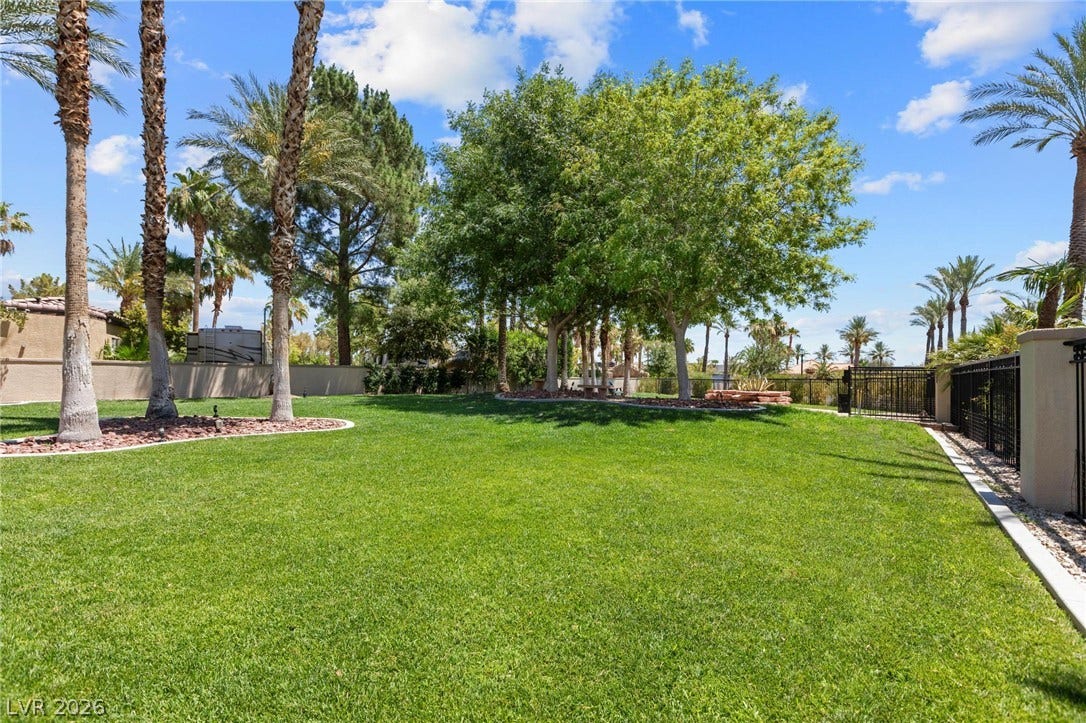 8175 Arville Street, #293, Las Vegas, NV 89139 Mature trees and tropical palms frame a manicured lawn under open skies.