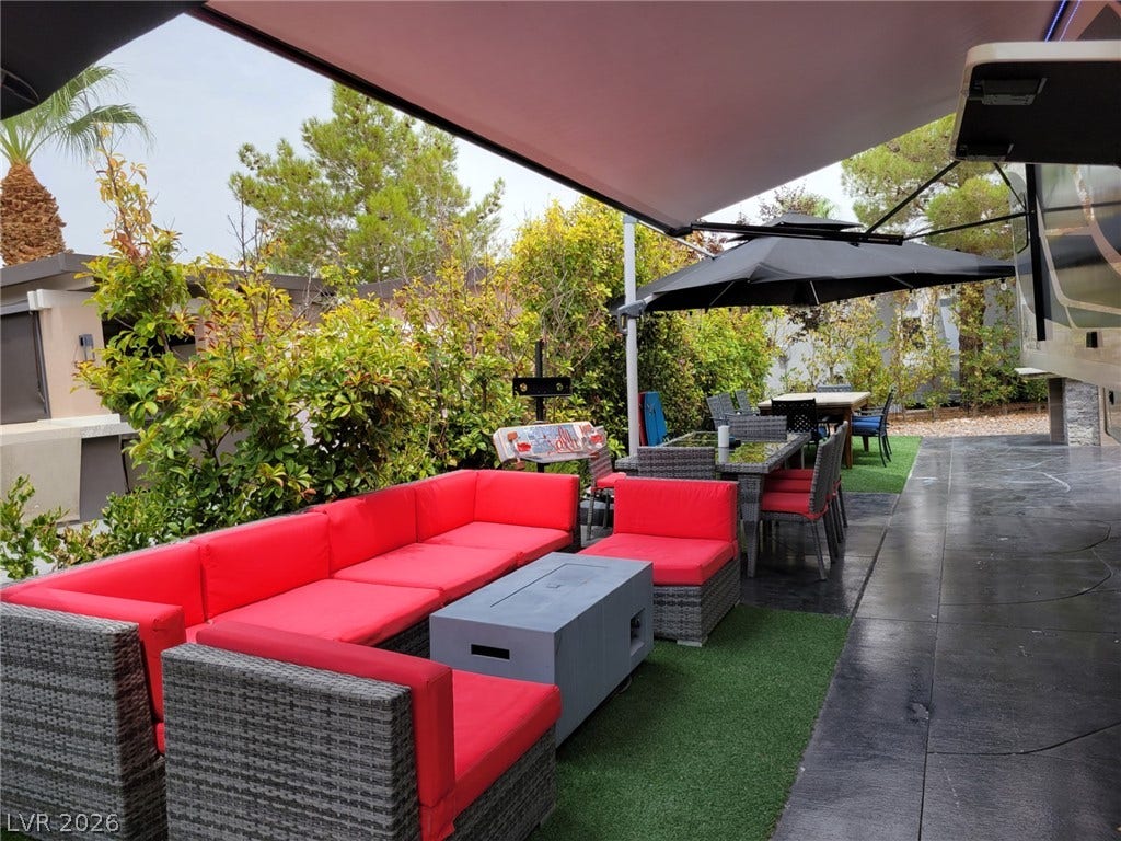8175 Arville Street, #293, Las Vegas, NV 89139 Retractable awnings shade an inviting outdoor living area bordered by lush privacy hedges.