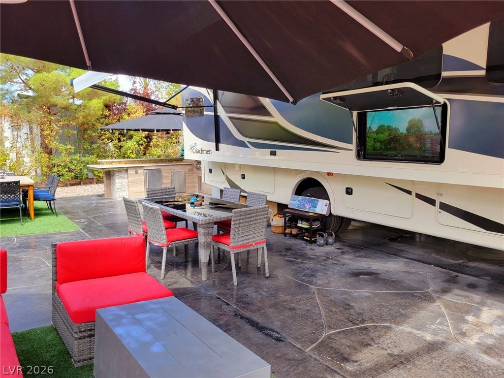 8175 Arville Street, #293, Las Vegas, NV 89139 A fully paved patio setup features built-in stone bar counters alongside a spacious recreational vehicle.