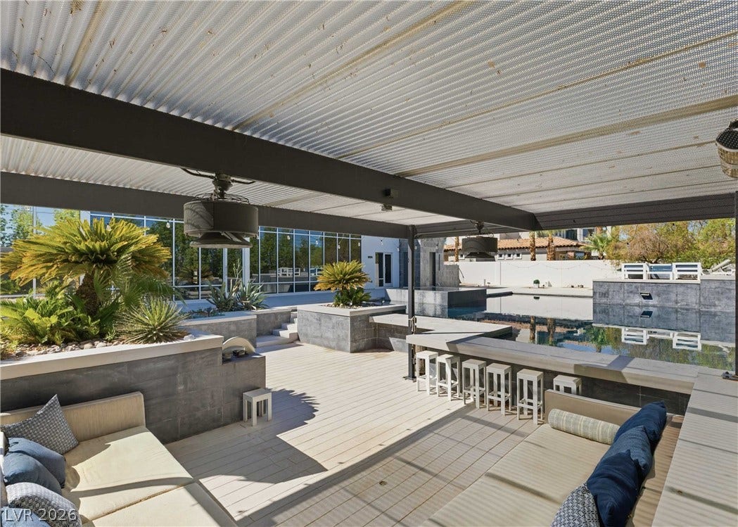 3716 Caesars Circle, Las Vegas, NV 89120 An expansive covered patio features integrated bar seating overlooking a private pool.