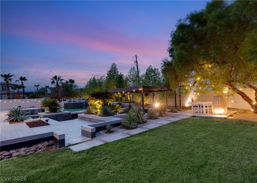 3716 Caesars Circle, Las Vegas, NV 89120 Lush landscaping and stone pathways create a serene outdoor oasis perfect for evening relaxation.
