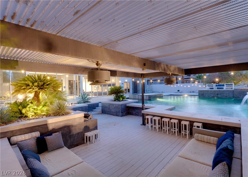 3716 Caesars Circle, Las Vegas, NV 89120 An inviting covered patio features integrated bench seating alongside a pristine backyard swimming pool.