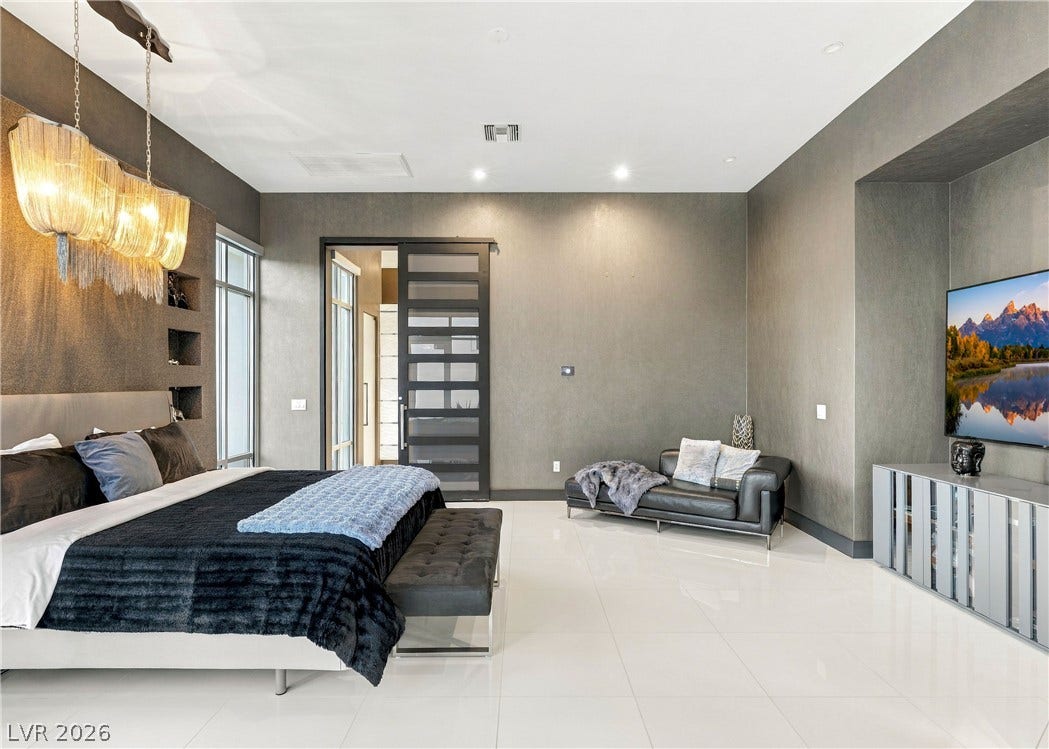 3716 Caesars Circle, Las Vegas, NV 89120 Polished tile flooring and textured walls define this modern main bedroom retreat.