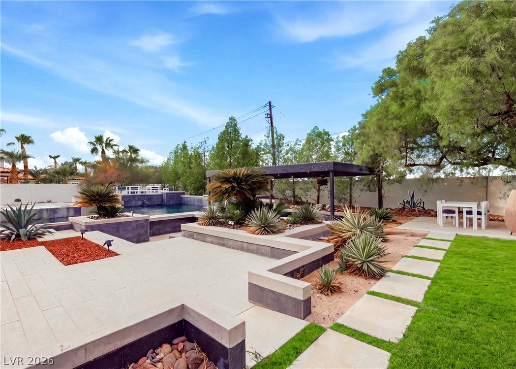 3716 Caesars Circle, Las Vegas, NV 89120 Lush landscaping and stone pavers frame this modern desert backyard retreat with a swimming pool.