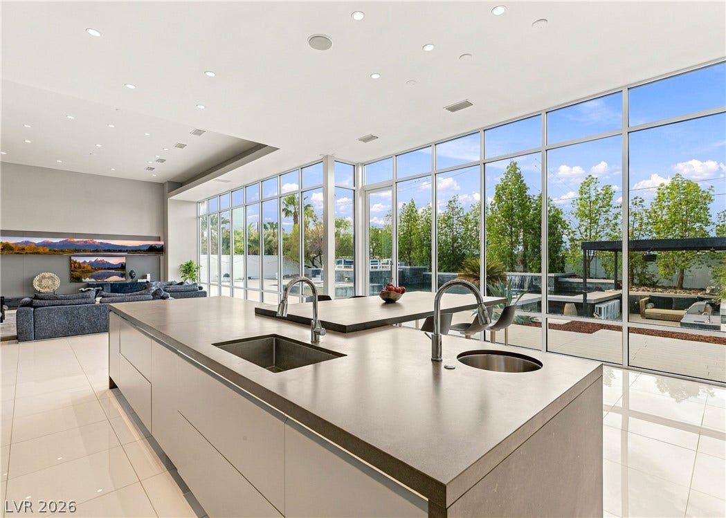 3716 Caesars Circle, Las Vegas, NV 89120 Towering window walls frame verdant backyard views from this modern open-concept kitchen.