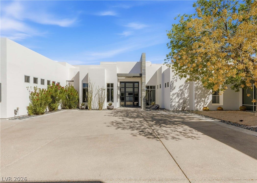 3716 Caesars Circle, Las Vegas, NV 89120 Clean lines and a spacious concrete driveway define this modern desert facade.