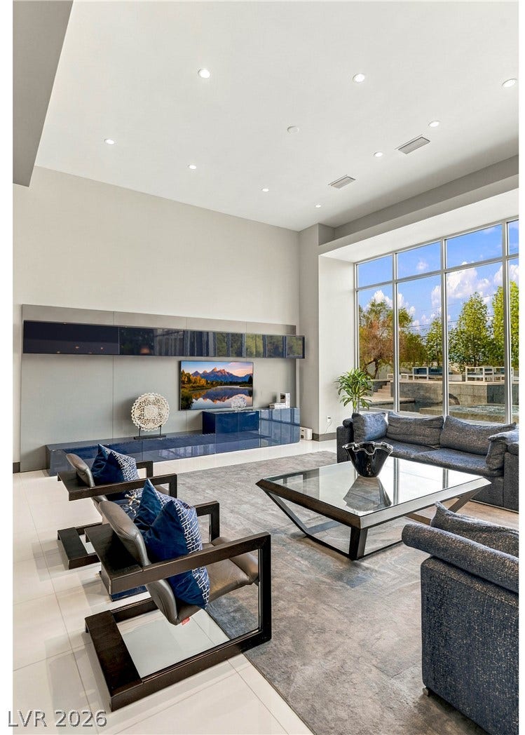 3716 Caesars Circle, Las Vegas, NV 89120 Massive floor-to-ceiling windows illuminate a contemporary living space finished with recessed lighting and tile flooring.