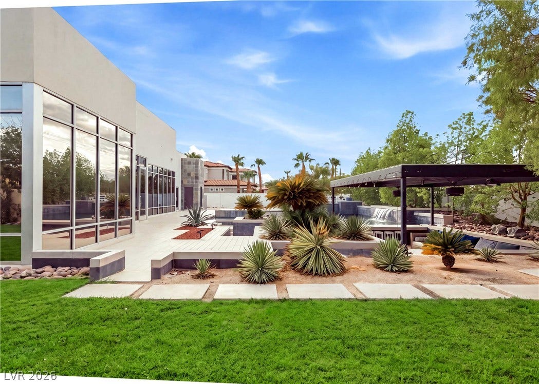 3716 Caesars Circle, Las Vegas, NV 89120 Lush lawns and architectural plantings frame this sleek modern patio and pool area.