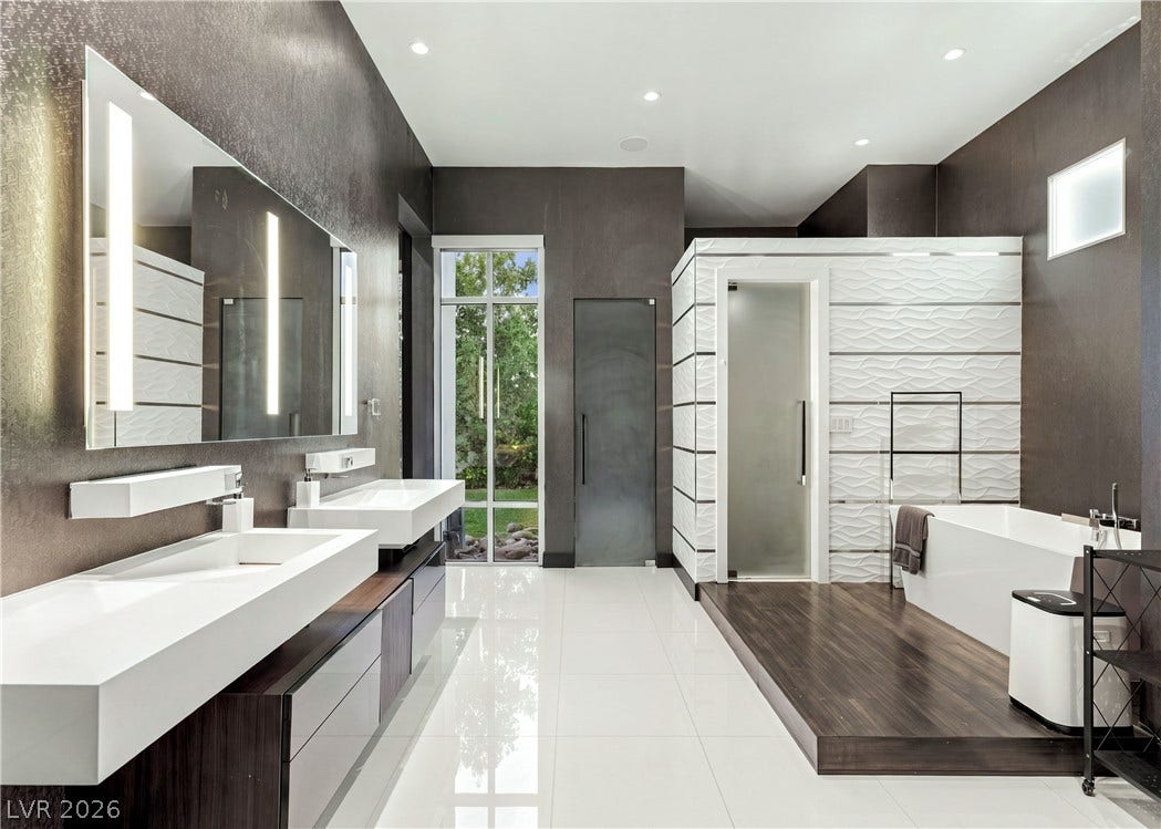 3716 Caesars Circle, Las Vegas, NV 89120 Gleaming tile floors and architectural lighting define this luxurious, spa-like primary bath oasis.