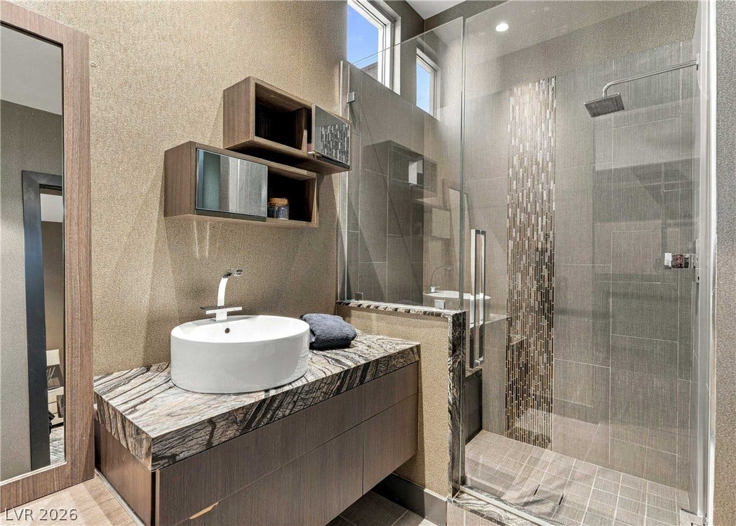 3716 Caesars Circle, Las Vegas, NV 89120 Exquisite stone counters and a sleek glass shower define this contemporary bathroom.