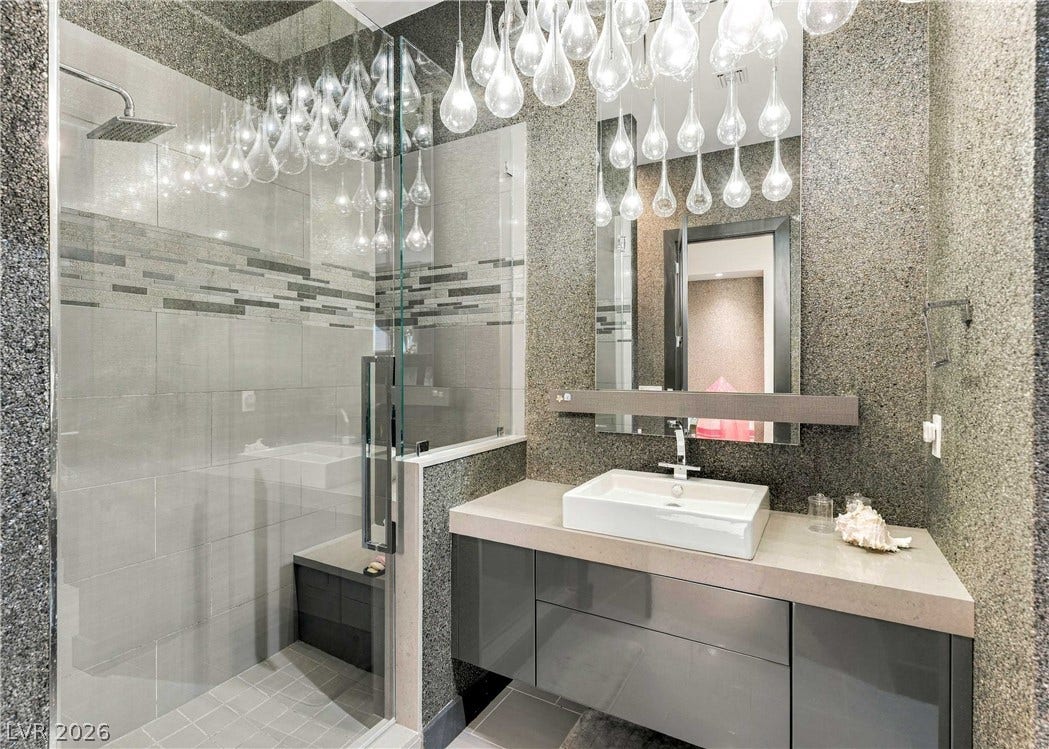 3716 Caesars Circle, Las Vegas, NV 89120 Modern floating vanity pairs with a glass-enclosed walk-in shower under custom lighting.