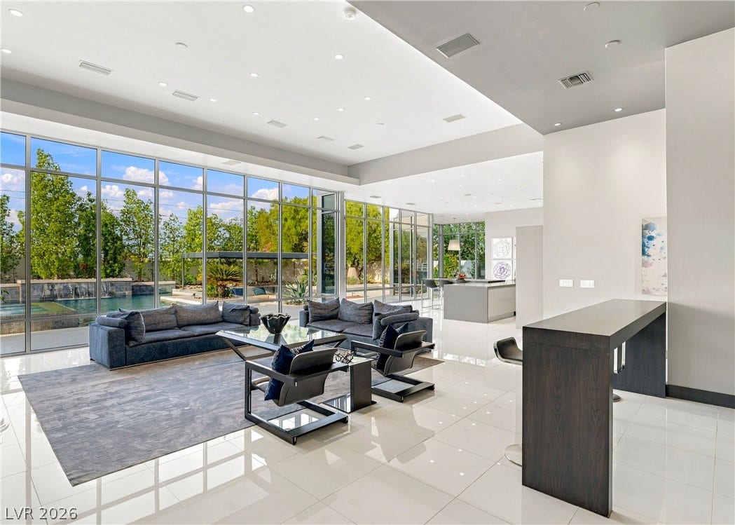 3716 Caesars Circle, Las Vegas, NV 89120 Floor-to-ceiling glass walls frame serene pool views from this modern living space.