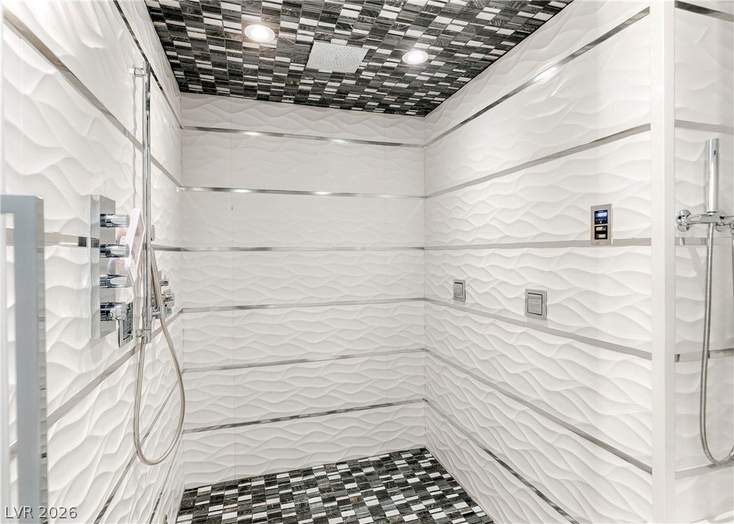 3716 Caesars Circle, Las Vegas, NV 89120 Textured tile walls and mosaic accents define this modern walk-in shower oasis.