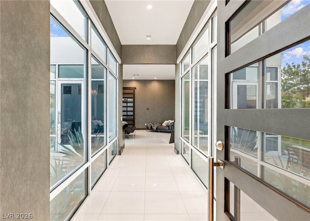 3716 Caesars Circle, Las Vegas, NV 89120 Gleaming tile floors line a dramatic hallway flanked by towering floor-to-ceiling windows.