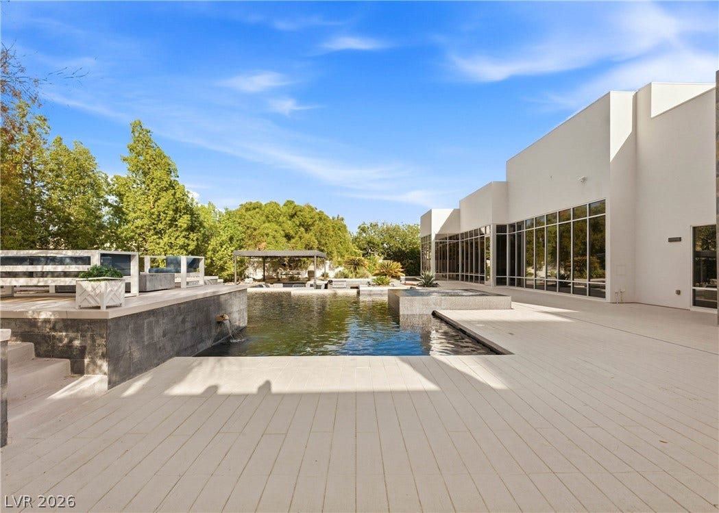 3716 Caesars Circle, Las Vegas, NV 89120 A spacious stone patio surrounds a pristine swimming pool beneath clear blue skies.