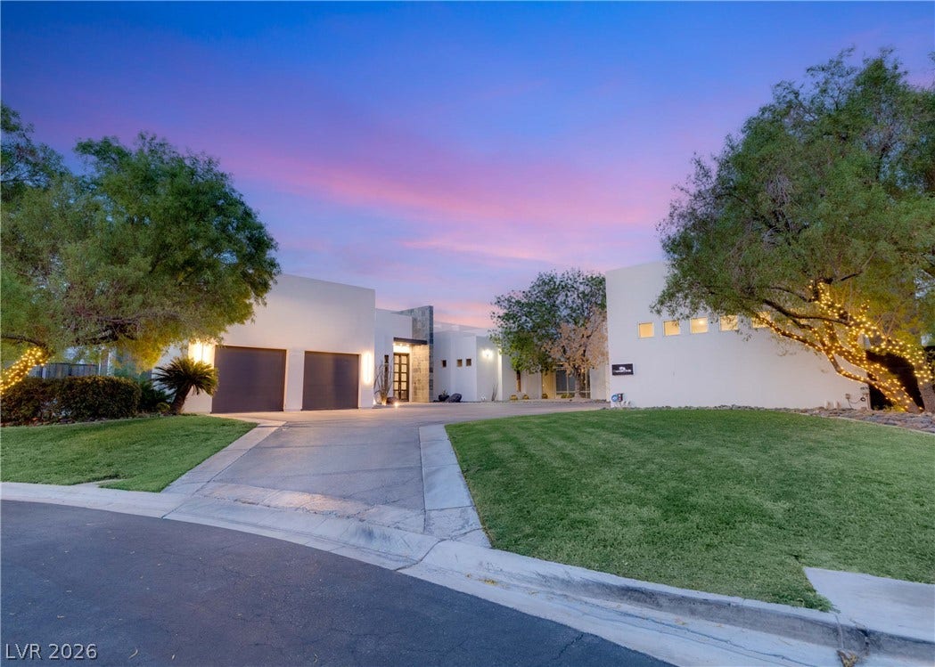 3716 Caesars Circle, Las Vegas, NV 89120 Manicured lawns frame a paved driveway leading to this modern stucco exterior at sunset.