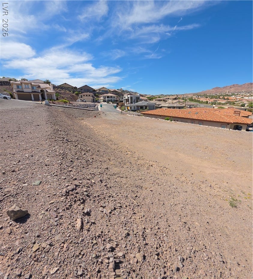 892 Jasper Way, Boulder City, NV 89005 Expansive desert lot offers panoramic mountain and neighborhood views under wide blue skies.