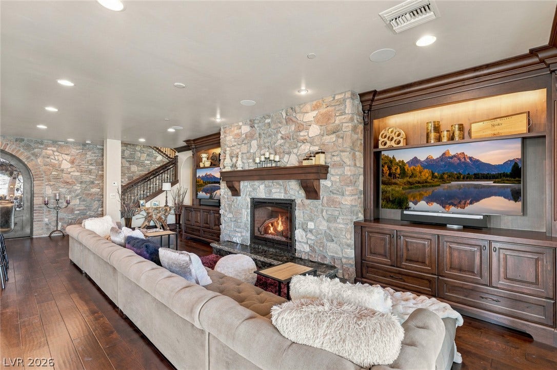 7 Lido Nord, Henderson, NV 89011 Rich wood floors and a magnificent floor-to-ceiling stone fireplace anchor this warm living area.