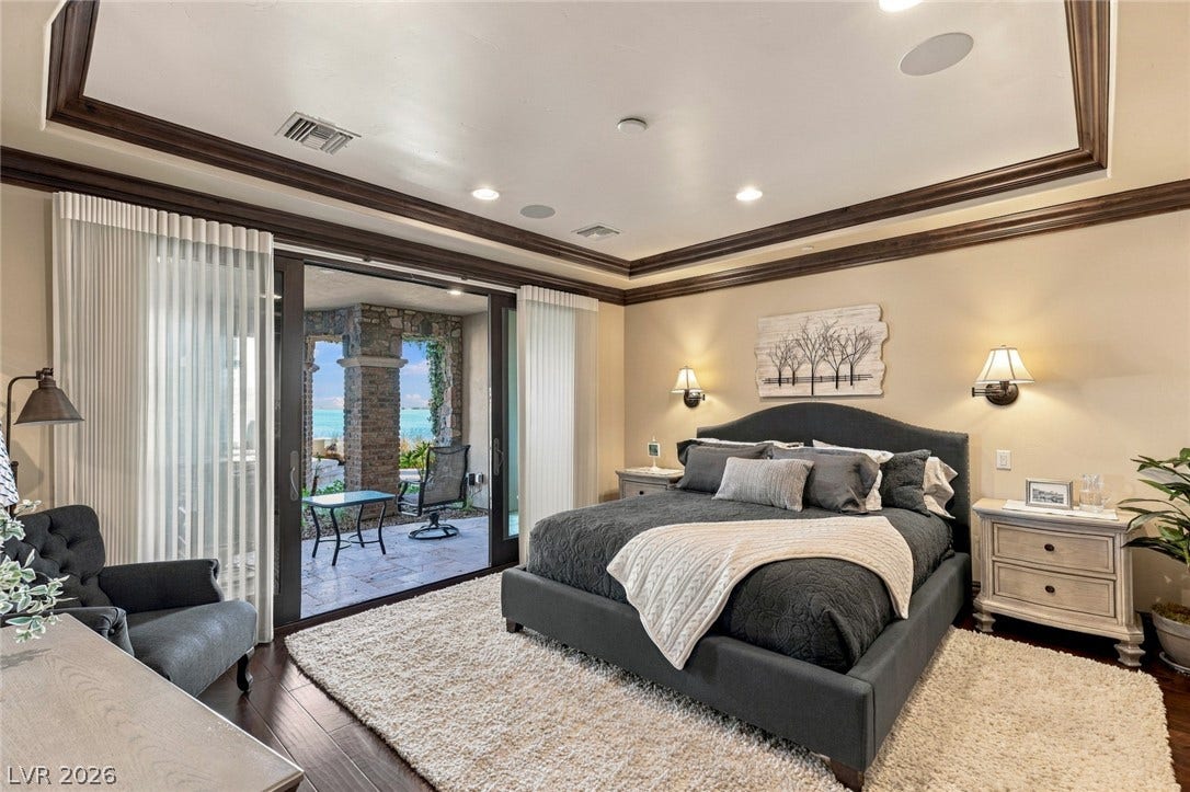 7 Lido Nord, Henderson, NV 89011 Sliding glass doors open from this bedroom to a private patio overlooking water views.