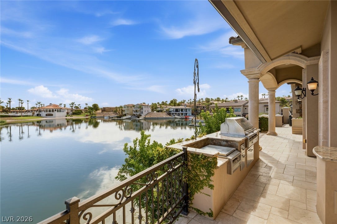 7 Lido Nord, Henderson, NV 89011 A spacious covered patio overlooking peaceful waters features a stone-countertop outdoor kitchen.