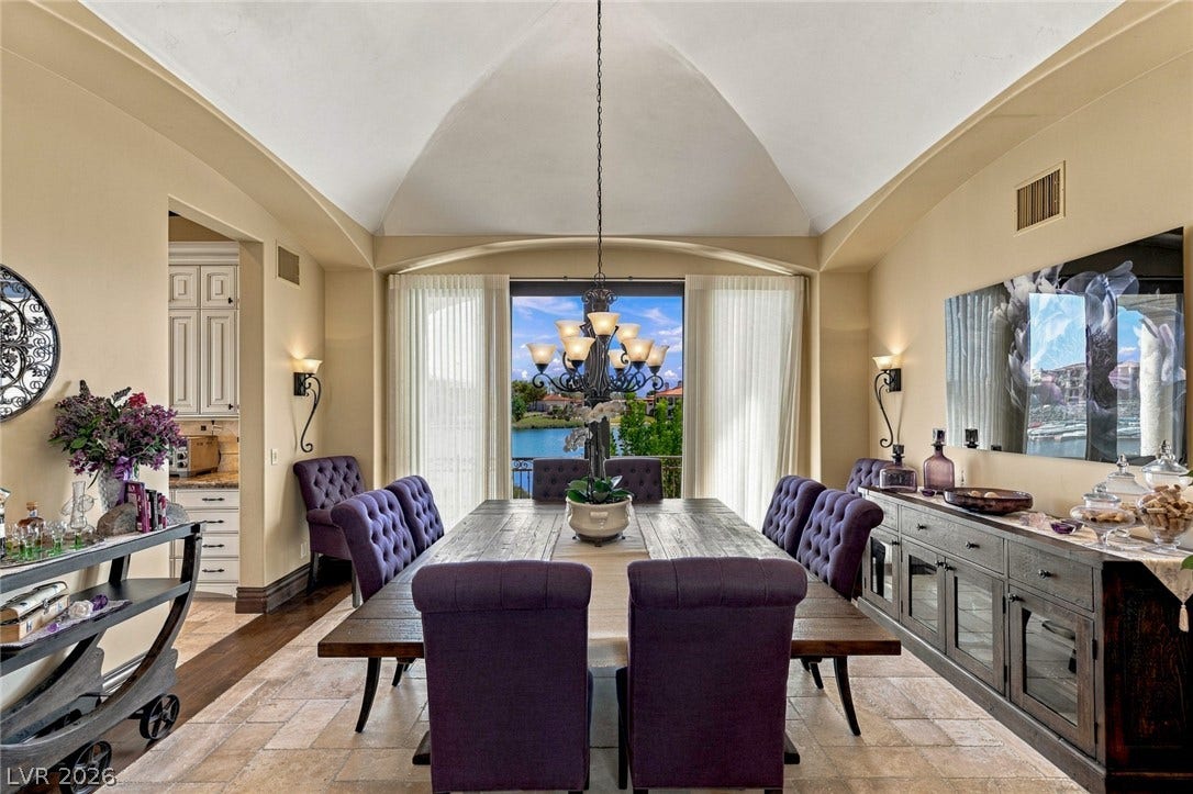 7 Lido Nord, Henderson, NV 89011 An elegant vaulted ceiling arches over a dining space overlooking tranquil waters.