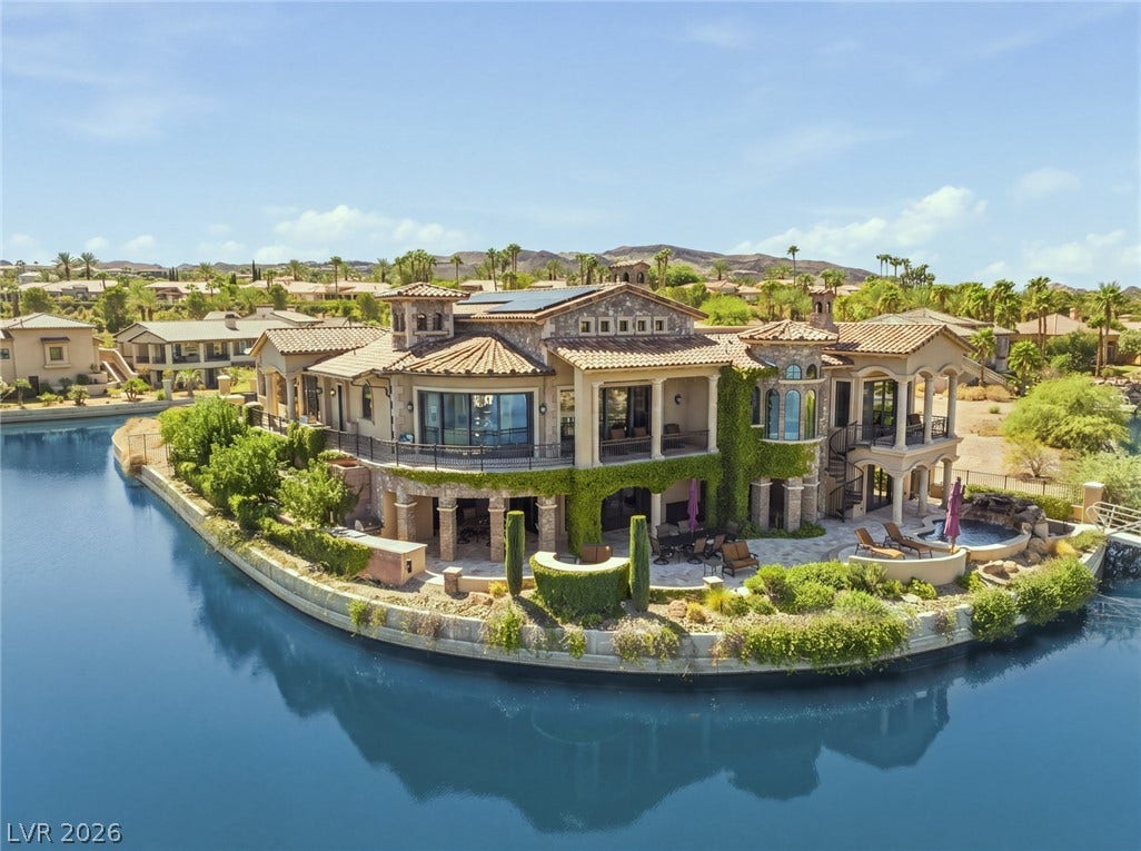7 Lido Nord, Henderson, NV 89011 A magnificent waterfront estate features stone accents, tiled roofing, and balconies overlooking the serene water.