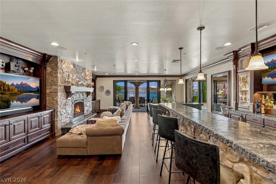 7 Lido Nord, Henderson, NV 89011 Rich hardwood floors and a massive stone fireplace anchor this expansive lakeside living space.