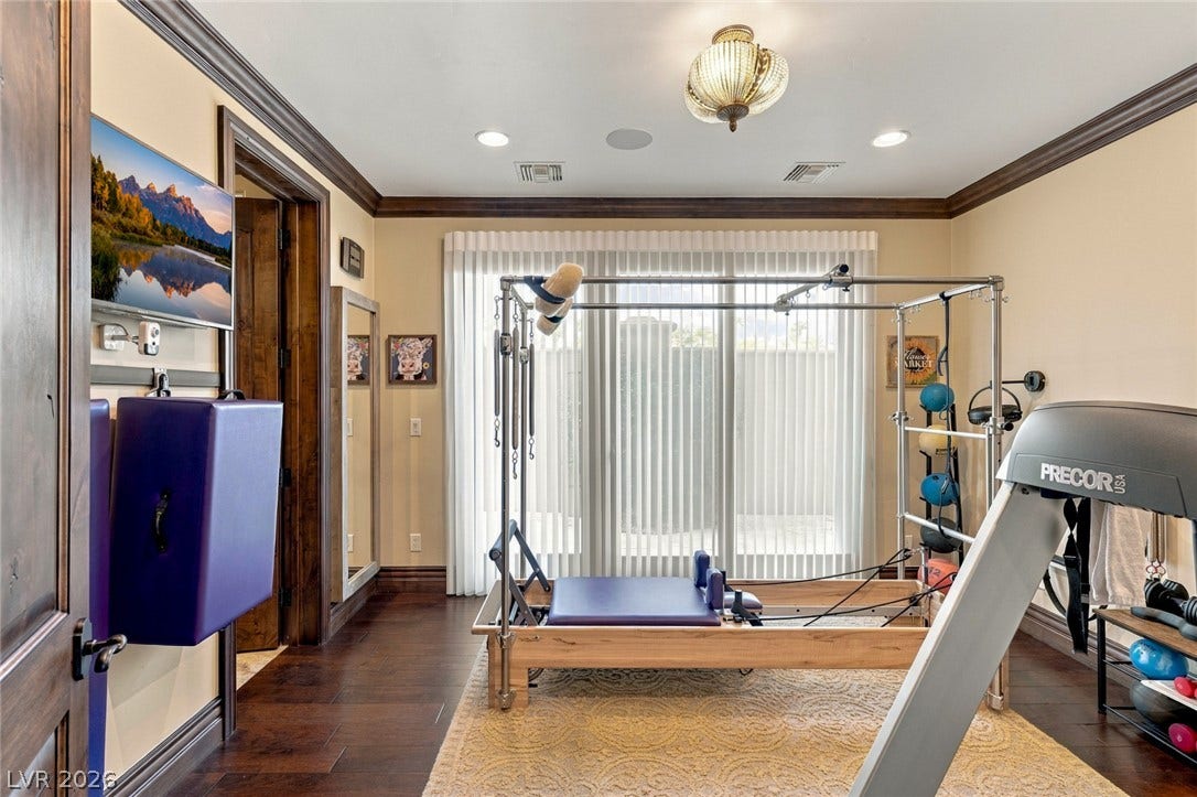 7 Lido Nord, Henderson, NV 89011 Rich hardwood floors and classic crown molding elevate this dedicated home exercise space.